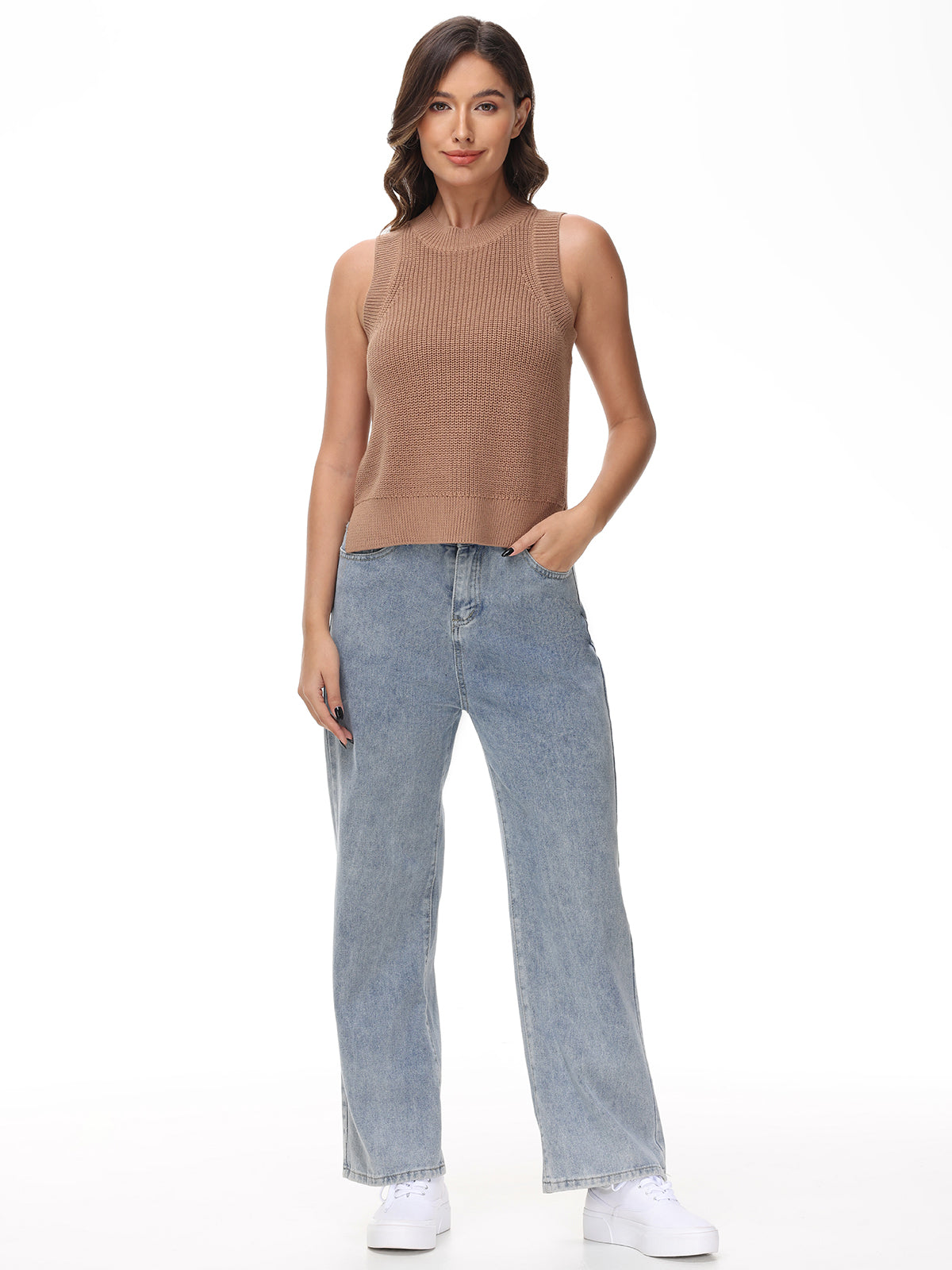 A woman models 525 America’s sleeveless brown knit crew neck top with light blue wide-leg jeans and white sneakers, posing with one hand in her pocket and a subtle smile that captures an effortlessly casual vibe.
