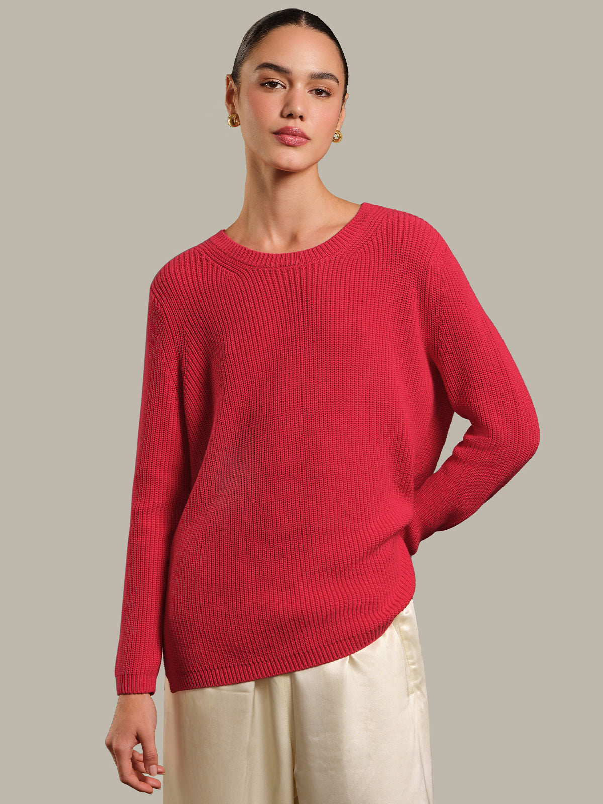 Woman wearing a red sweater against a neutral background