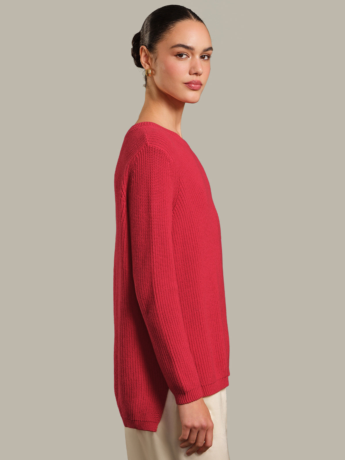 Woman wearing a red sweater against a plain background
