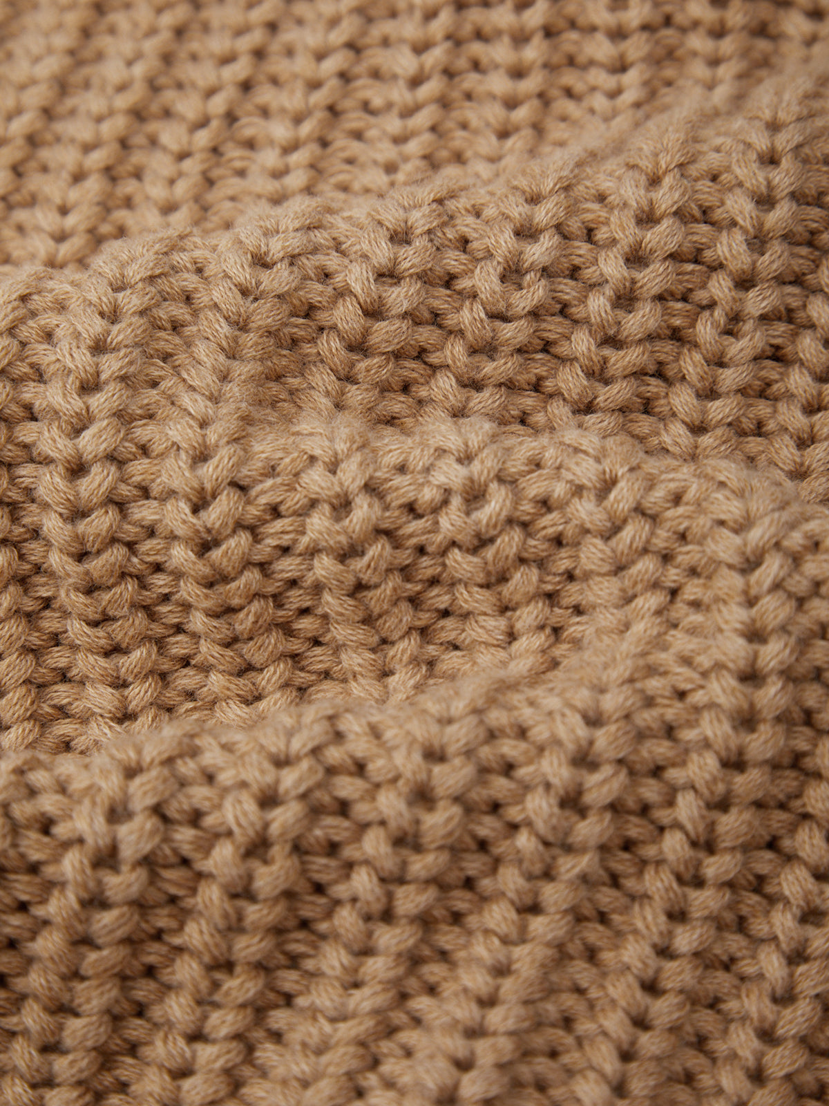 Close-up of a beige knitted fabric texture