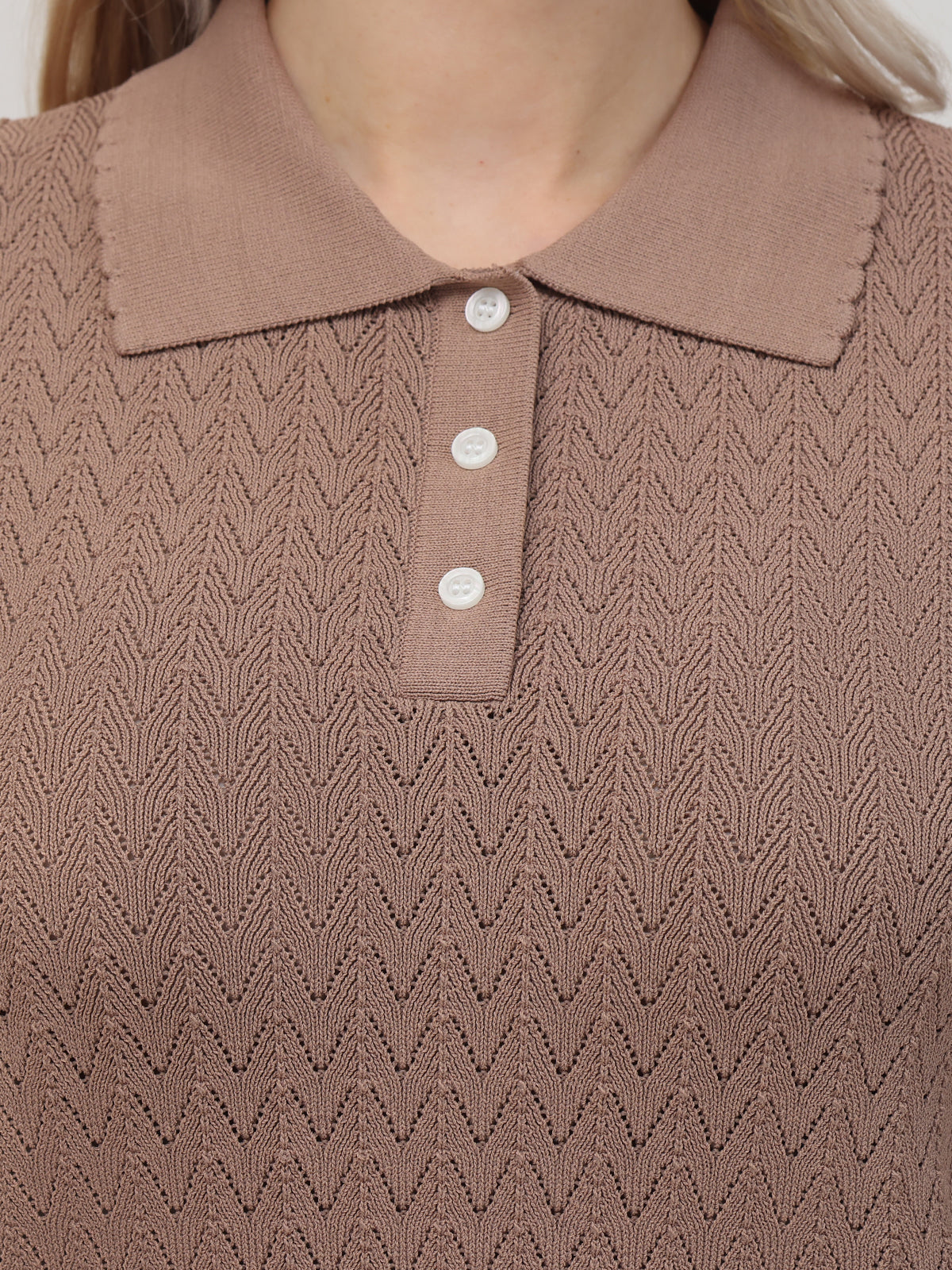 An elevated close-up of a brown knit polo by 525 America showcases its textured zigzag pattern, ribbed collar, and four-button placket. The neutral background highlights the classic polos fitted design and intricate details.