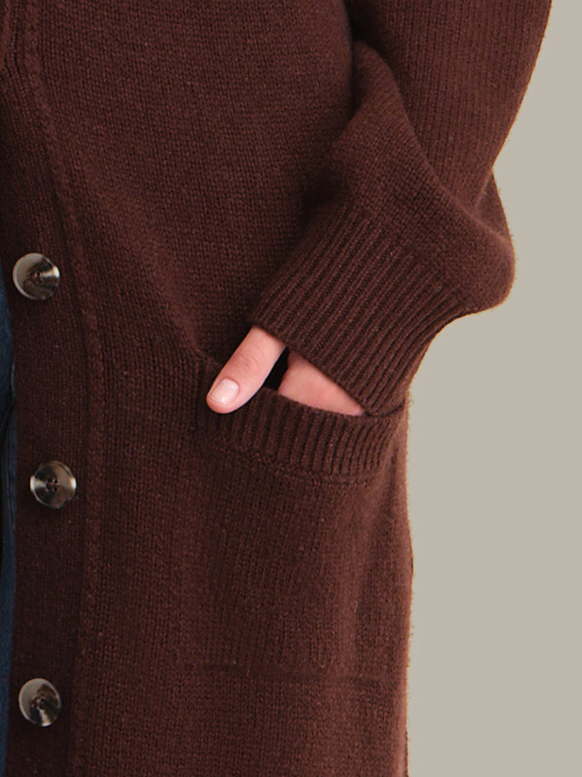 Brown cardigan with button details on a neutral background