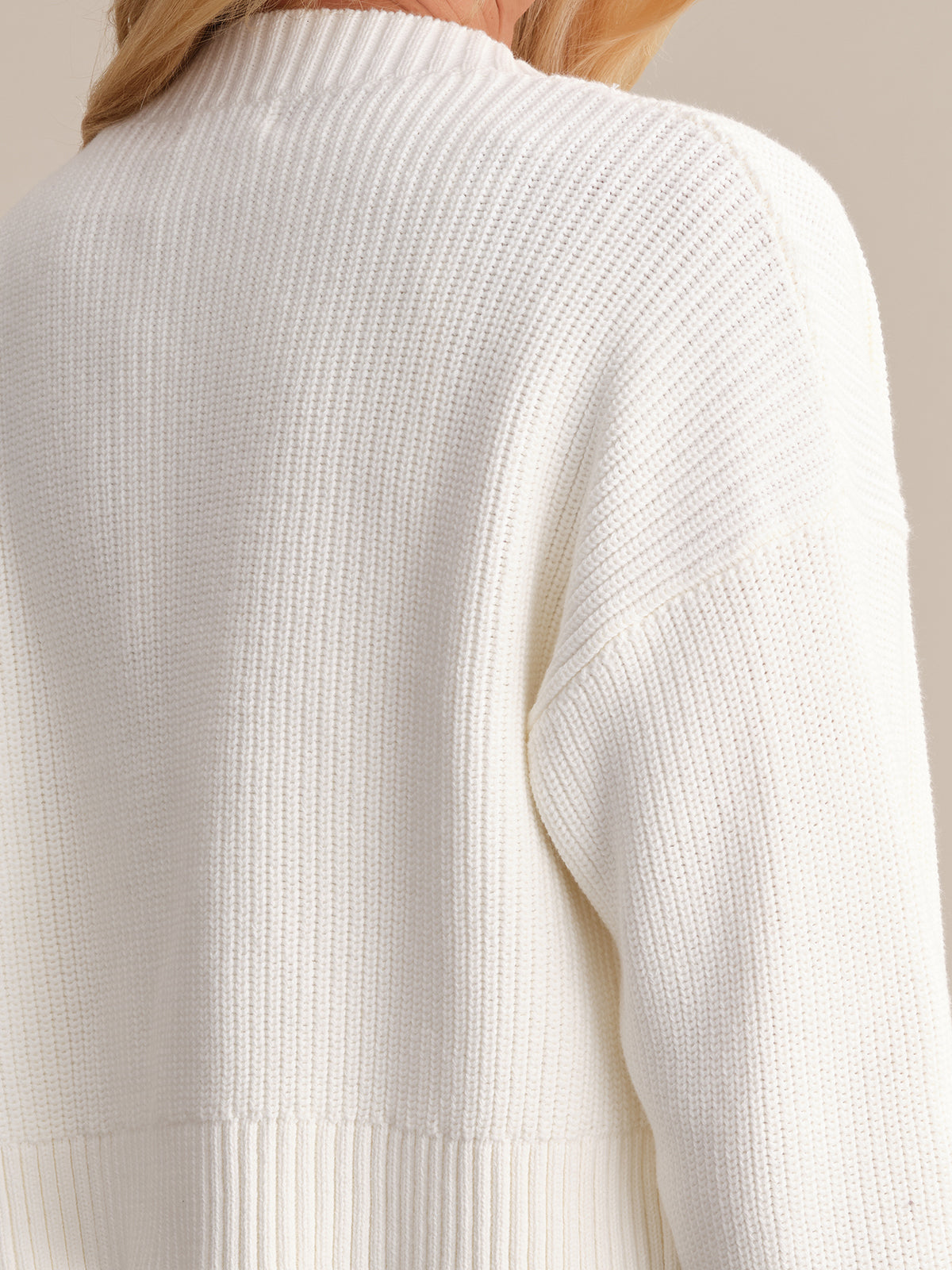 A close-up of the back of a person wearing a ribbed knit sweater by 525 America highlights its minimalist design, capturing the texture and pattern with partially visible blonde hair.