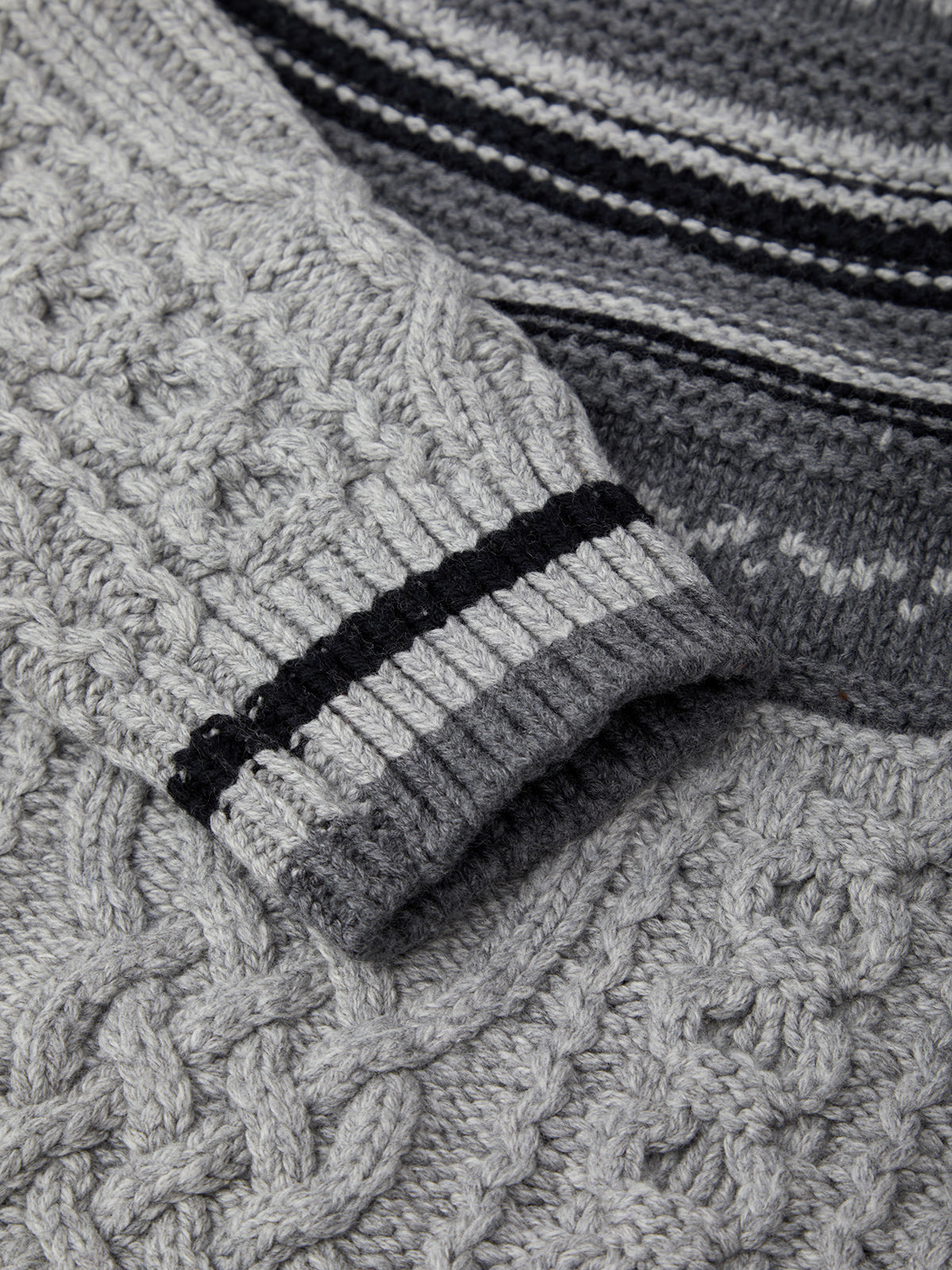 Close-up of a textured gray sweater with a black band