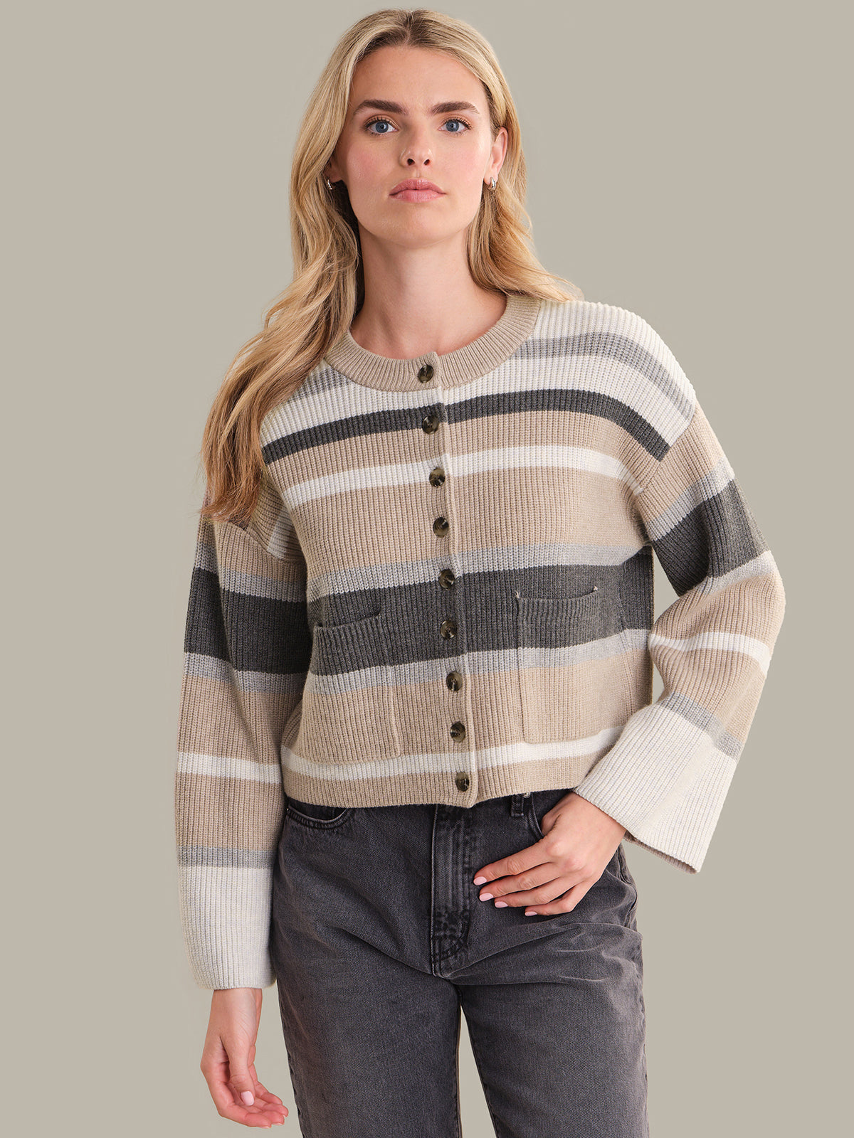 Woman wearing a striped sweater with a neutral background