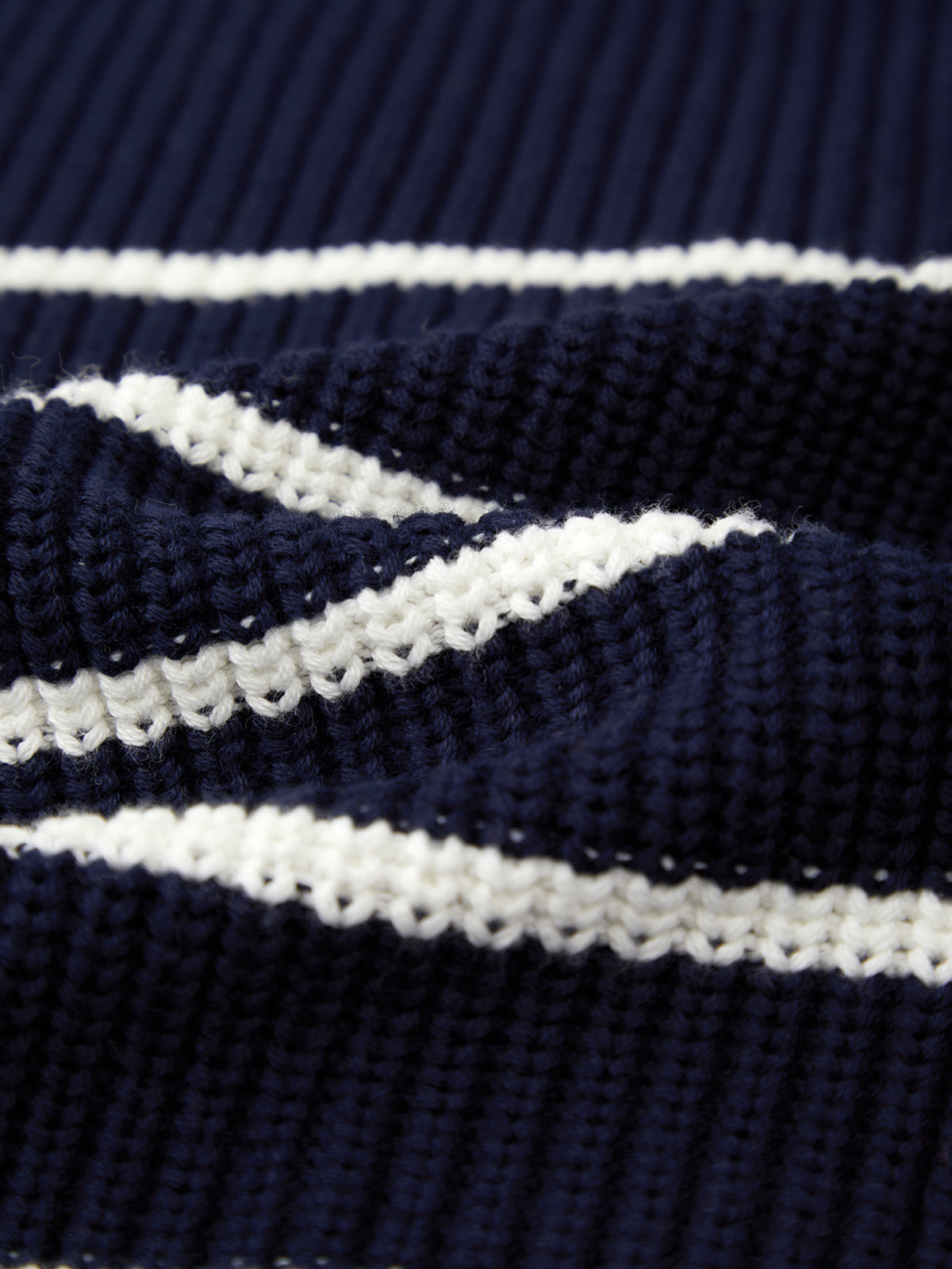 Close-up of 525 America’s navy blue knitted fabric with white stripes, showing detailed texture and ribbing—ideal for layering or achieving a relaxed, oversized look.