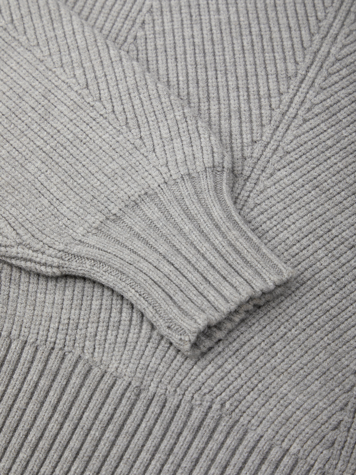 Close-up of a gray ribbed sweater with a focus on texture and pattern.
