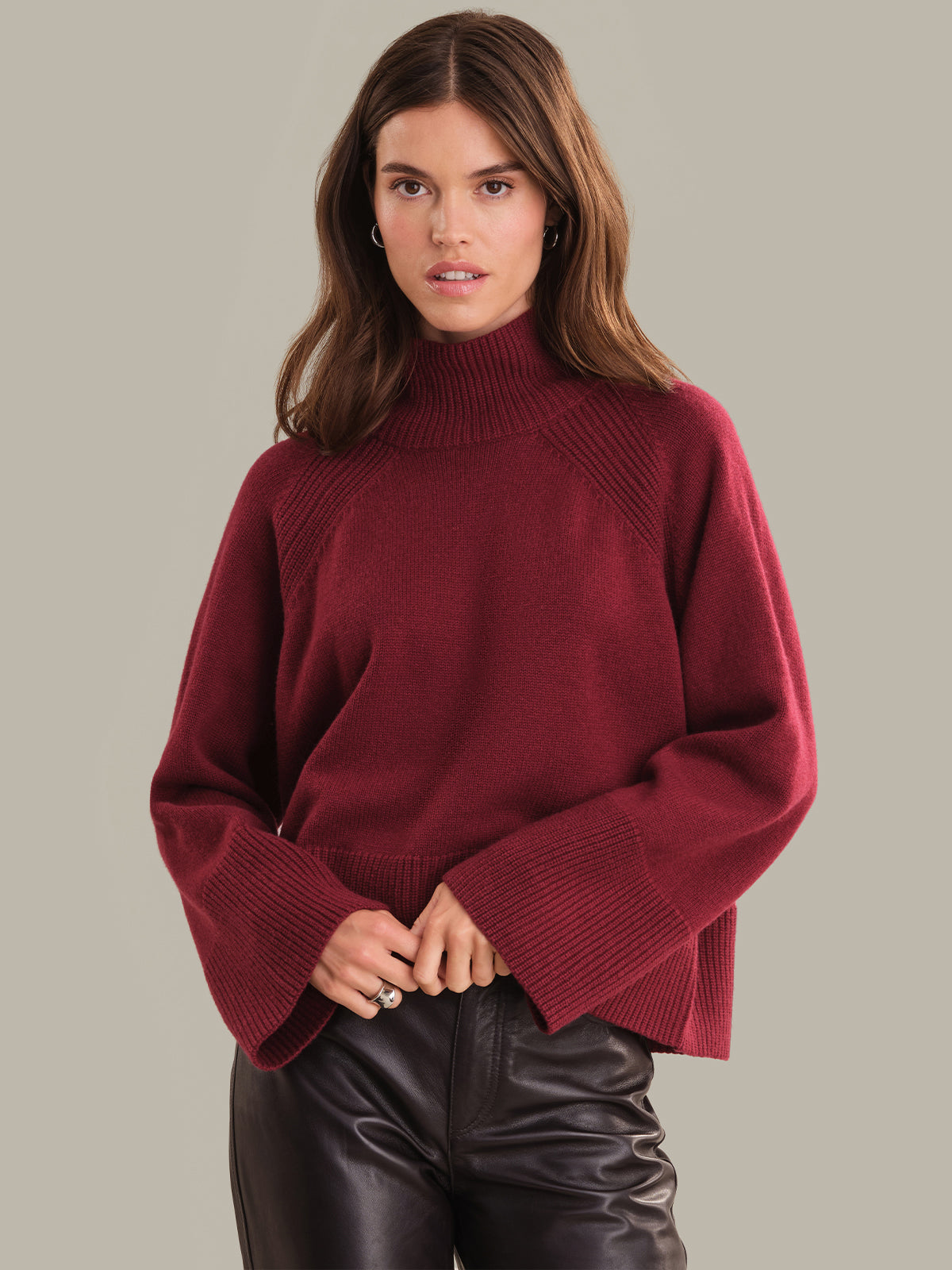 Woman wearing a burgundy sweater against a neutral background