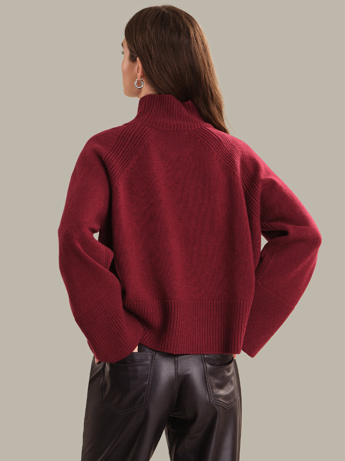 Person wearing a red sweater with a neutral background