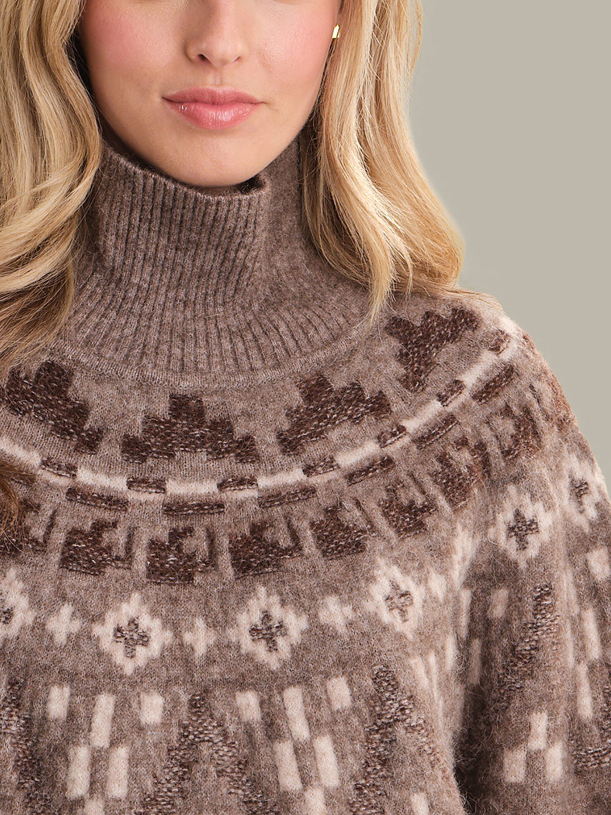 Close-up of a person wearing a patterned sweater with a neutral background