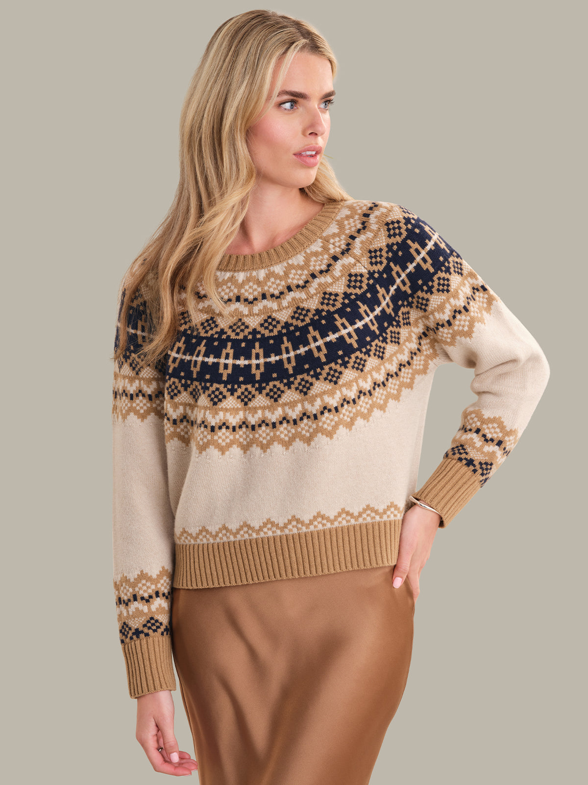 Woman wearing a patterned sweater with a neutral background