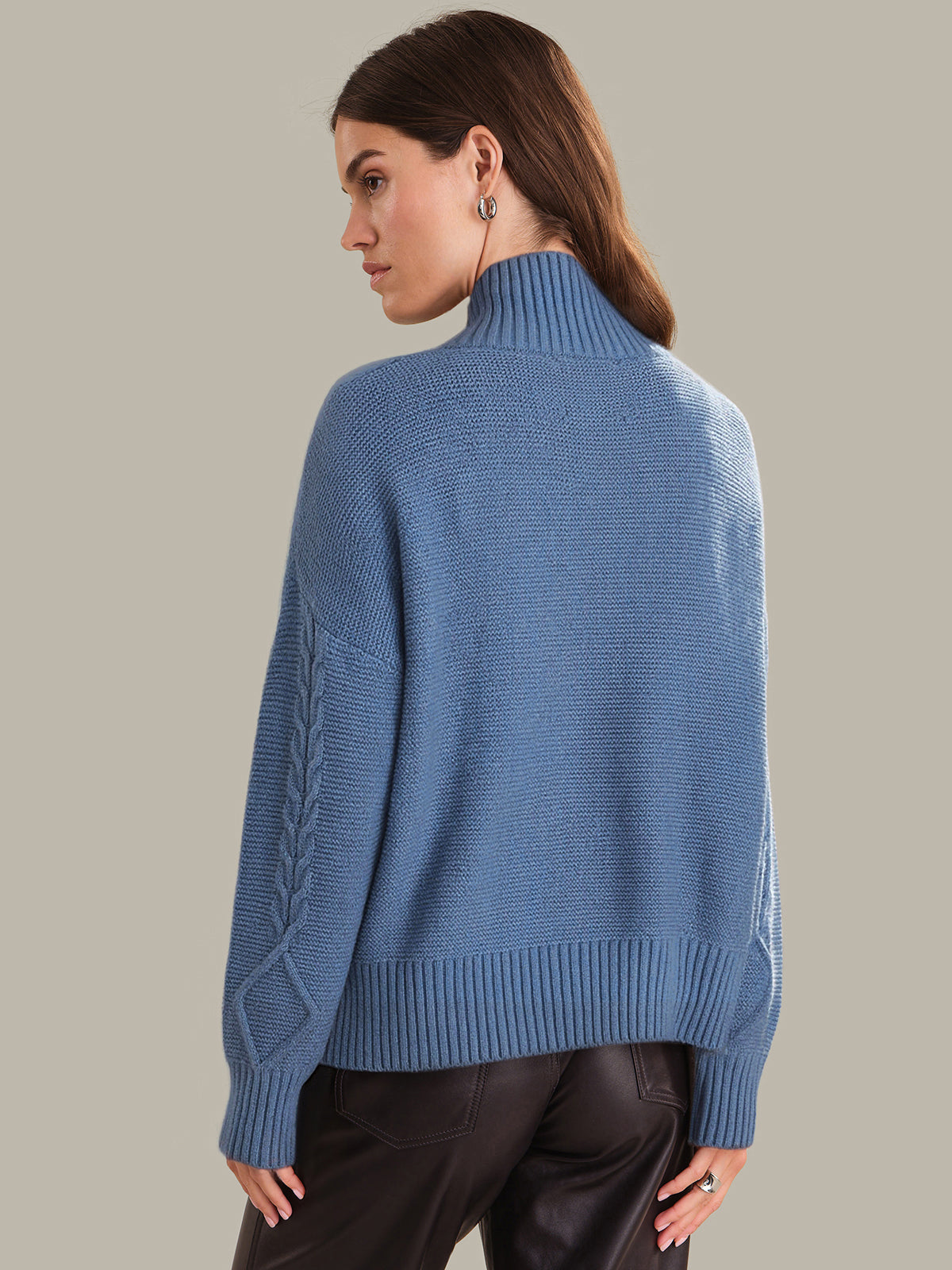 Woman wearing a blue sweater with a gray background