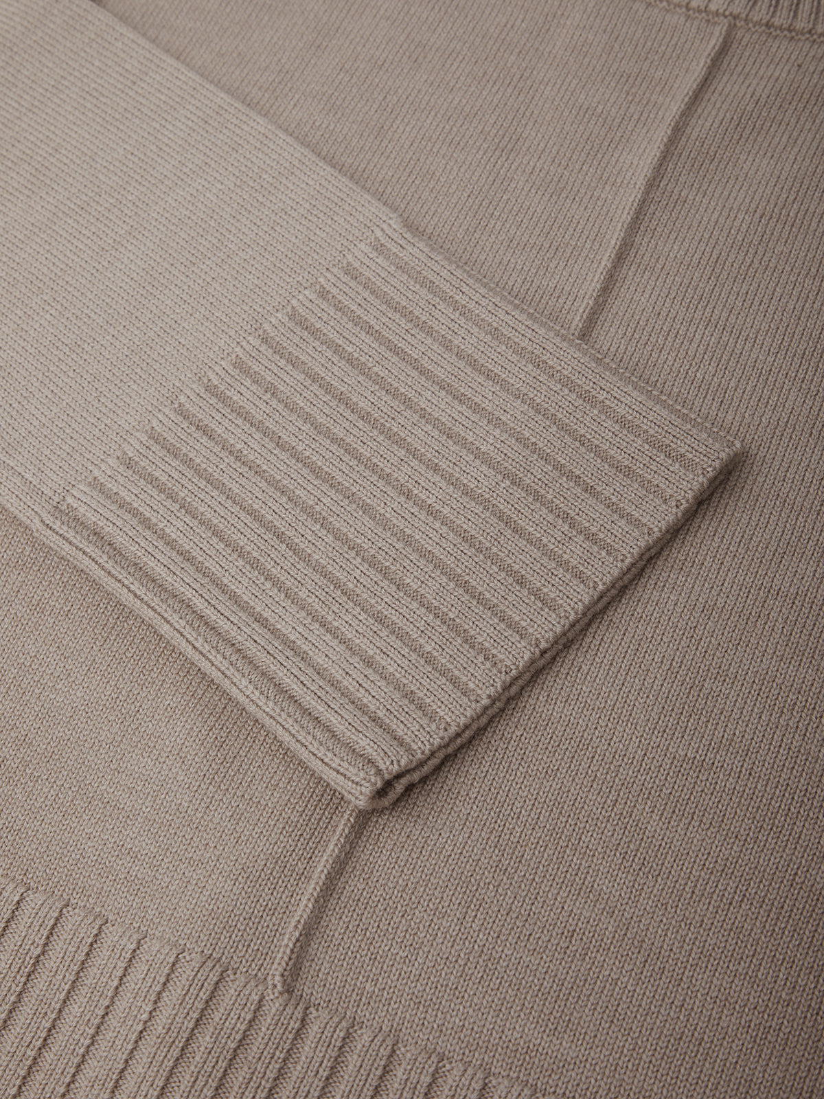 Close-up of a beige sweater with ribbed texture