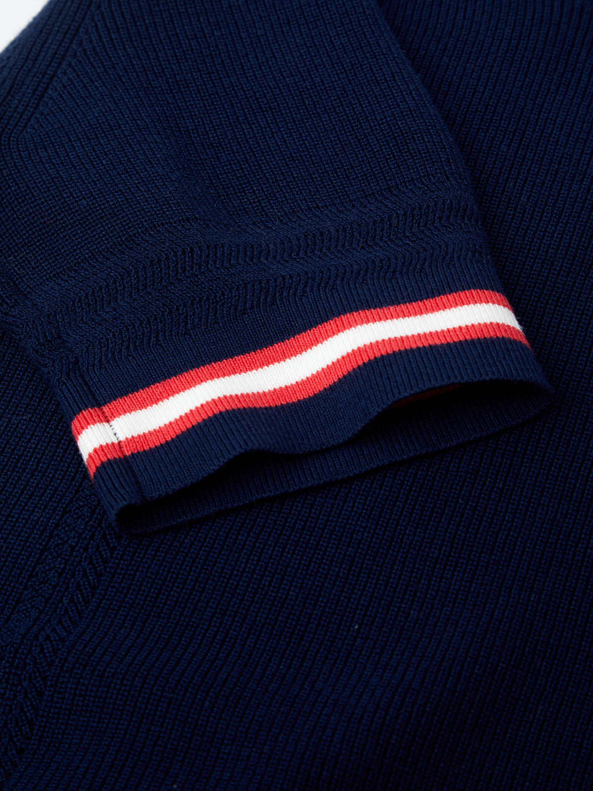 Navy blue sweater with a red and white striped cuff