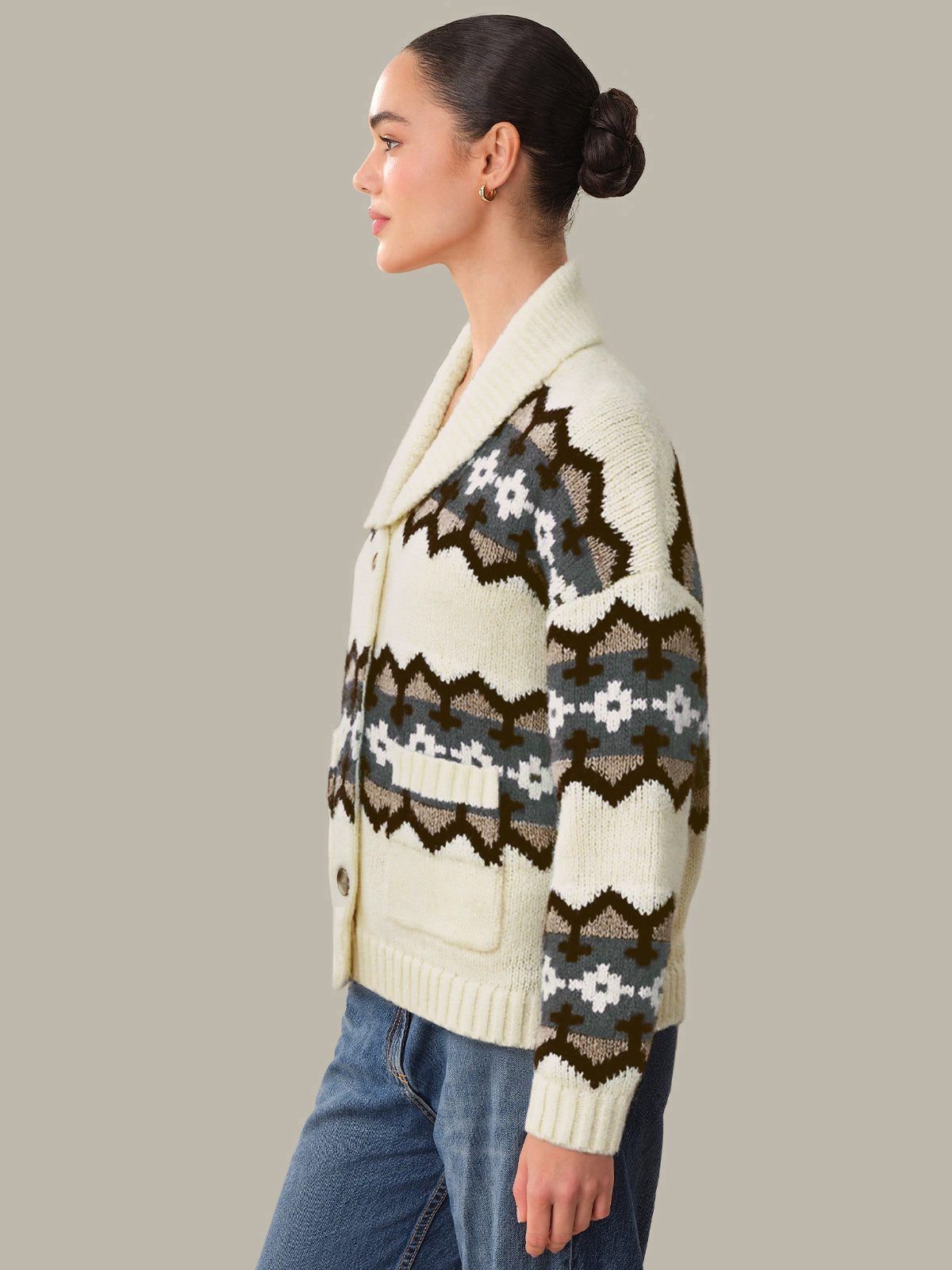 Woman wearing a patterned cardigan with a neutral background