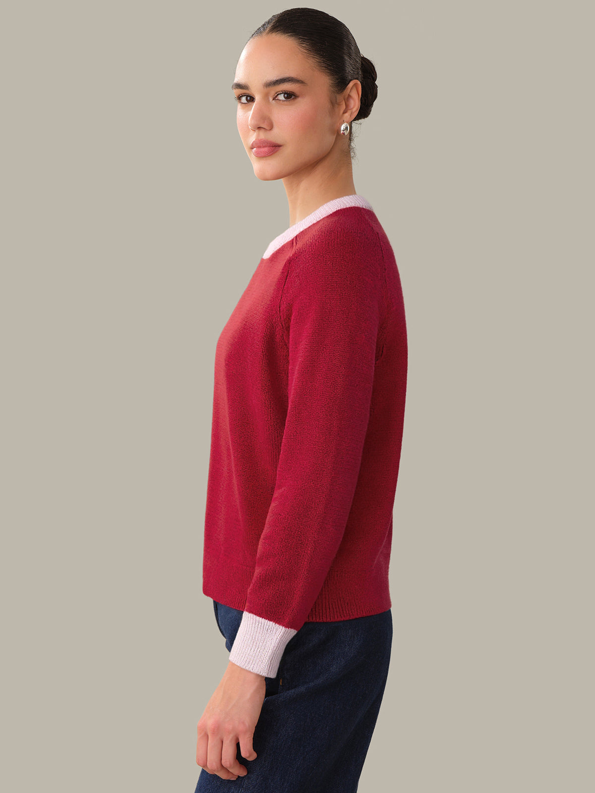 Woman wearing a red sweater with a plain background