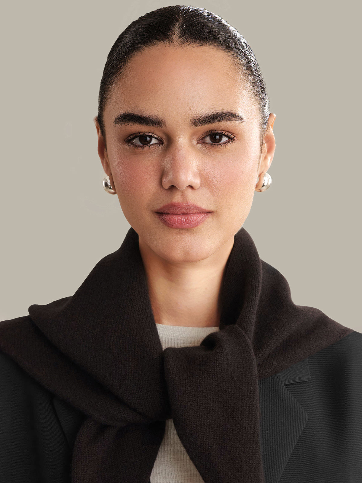Woman wearing a dark coat with a plain background
