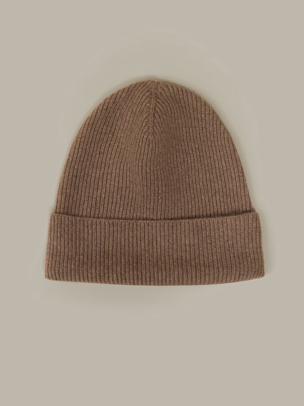 Brown knit beanie on a beige background