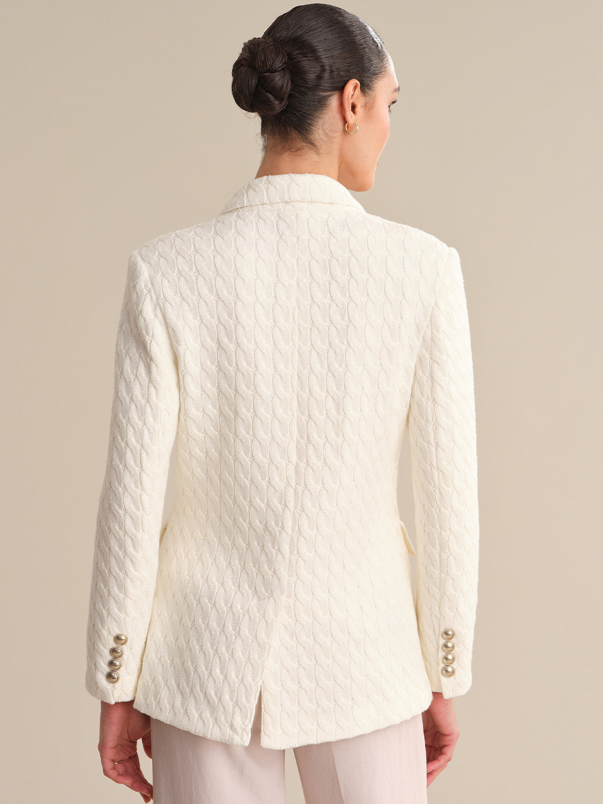 Person wearing a white quilted jacket on a beige background