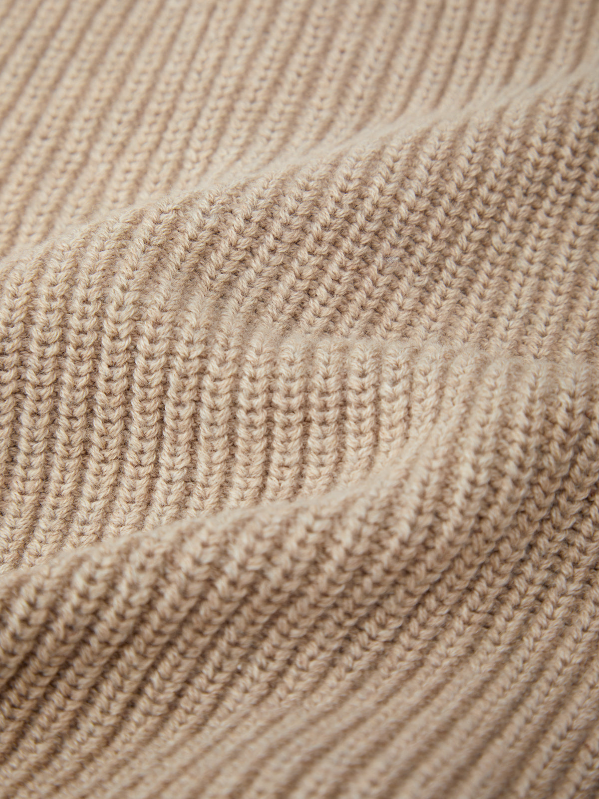 Close-up of beige knitted fabric texture