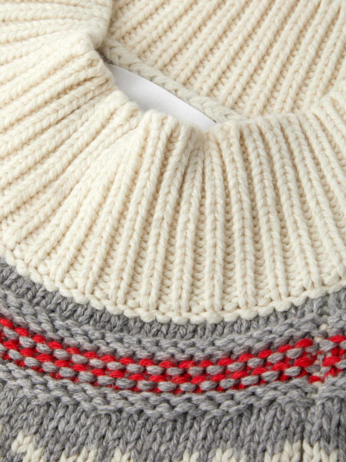 Close-up of a knitted fabric with red and gray pattern