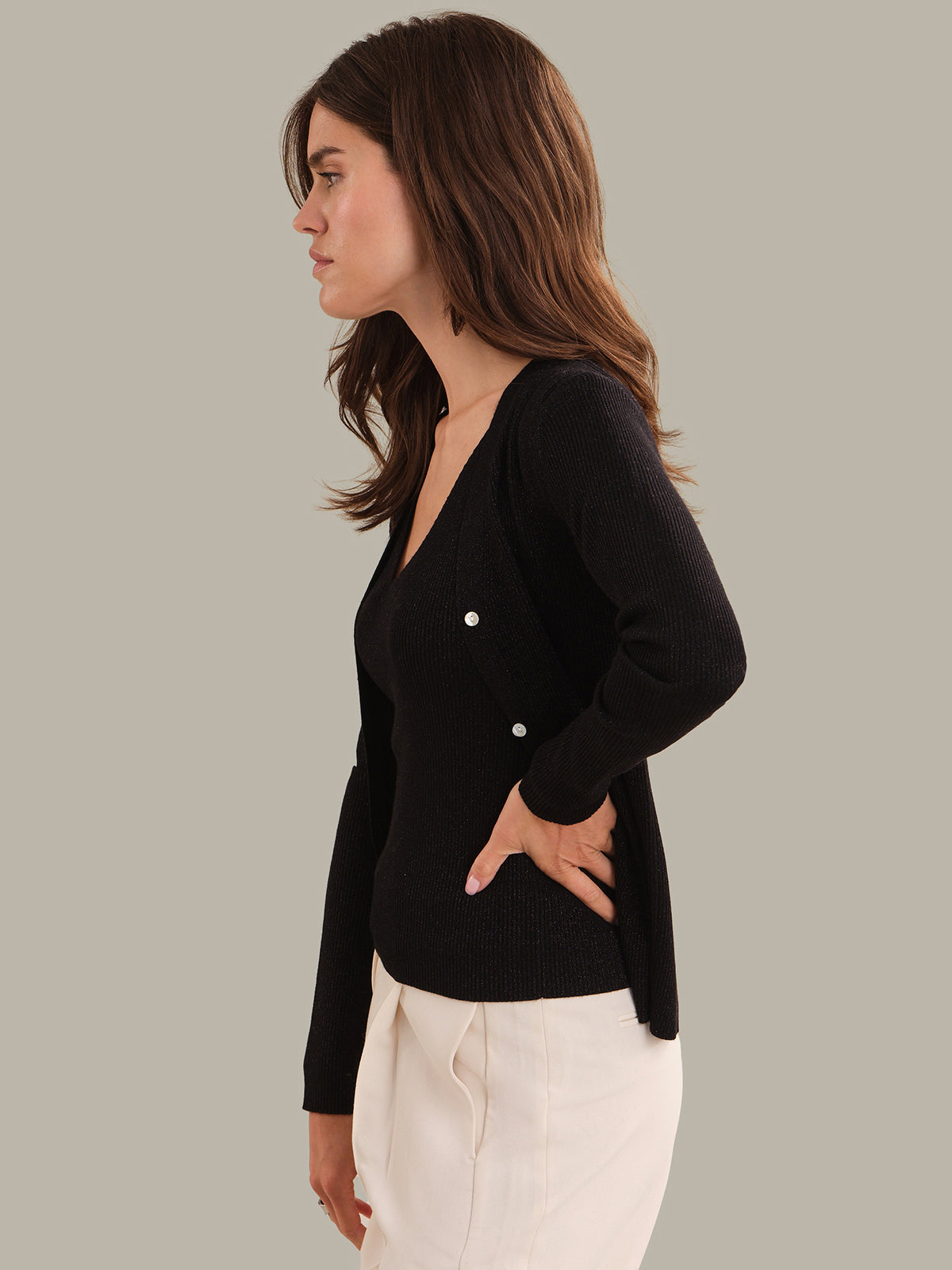 Woman wearing a black cardigan over a gray background