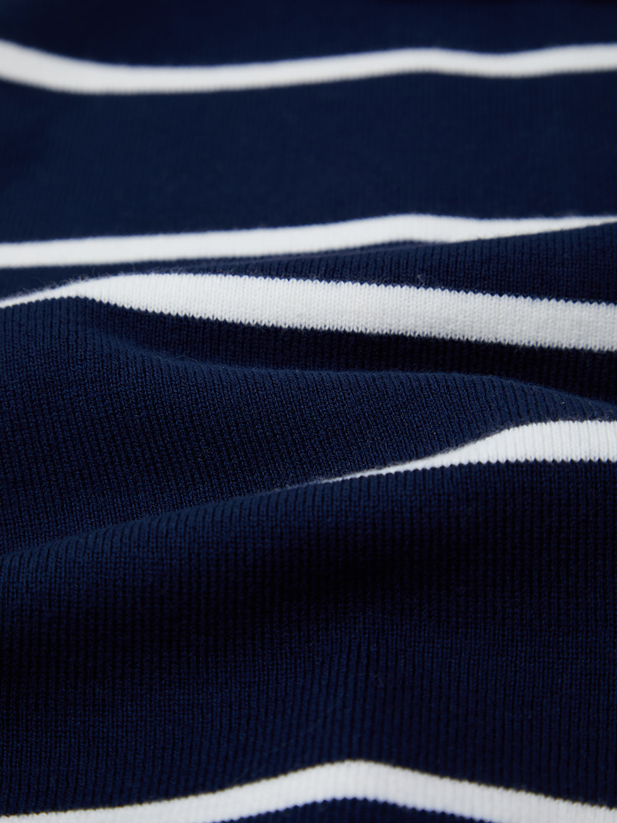 A close-up of 525 America’s premium cotton fabric in dark blue, featuring evenly spaced horizontal white stripes and a textured, ribbed surface.