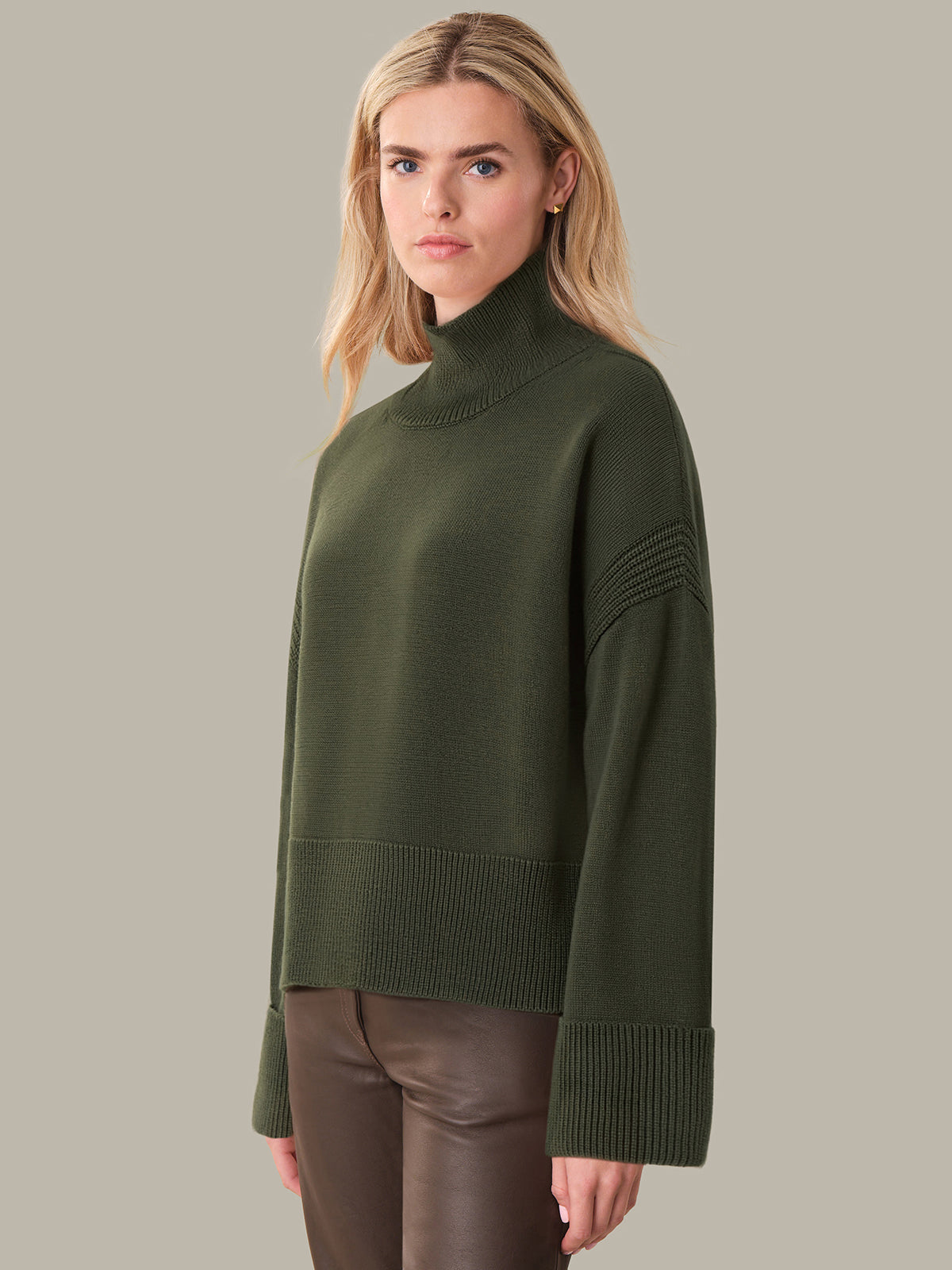 Woman wearing a green sweater against a neutral background