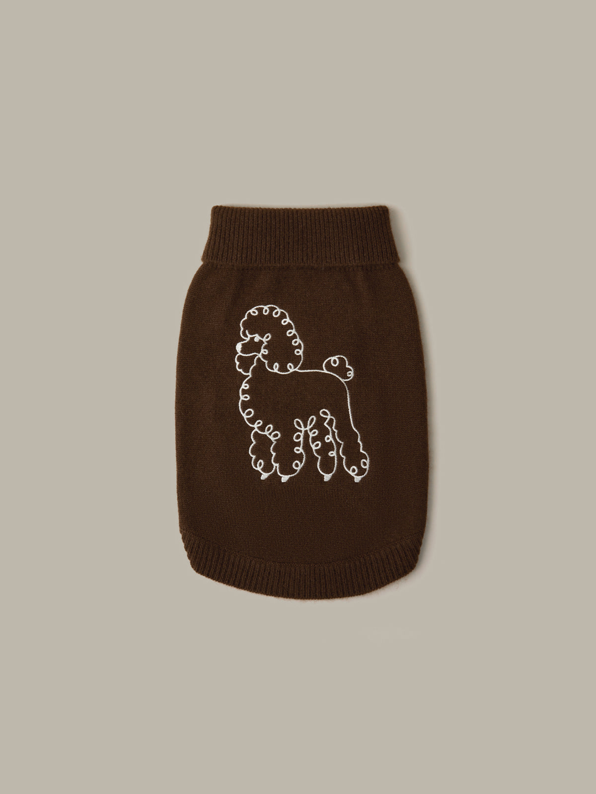 Brown knitted dog sweater with a white embroidered design on a beige background