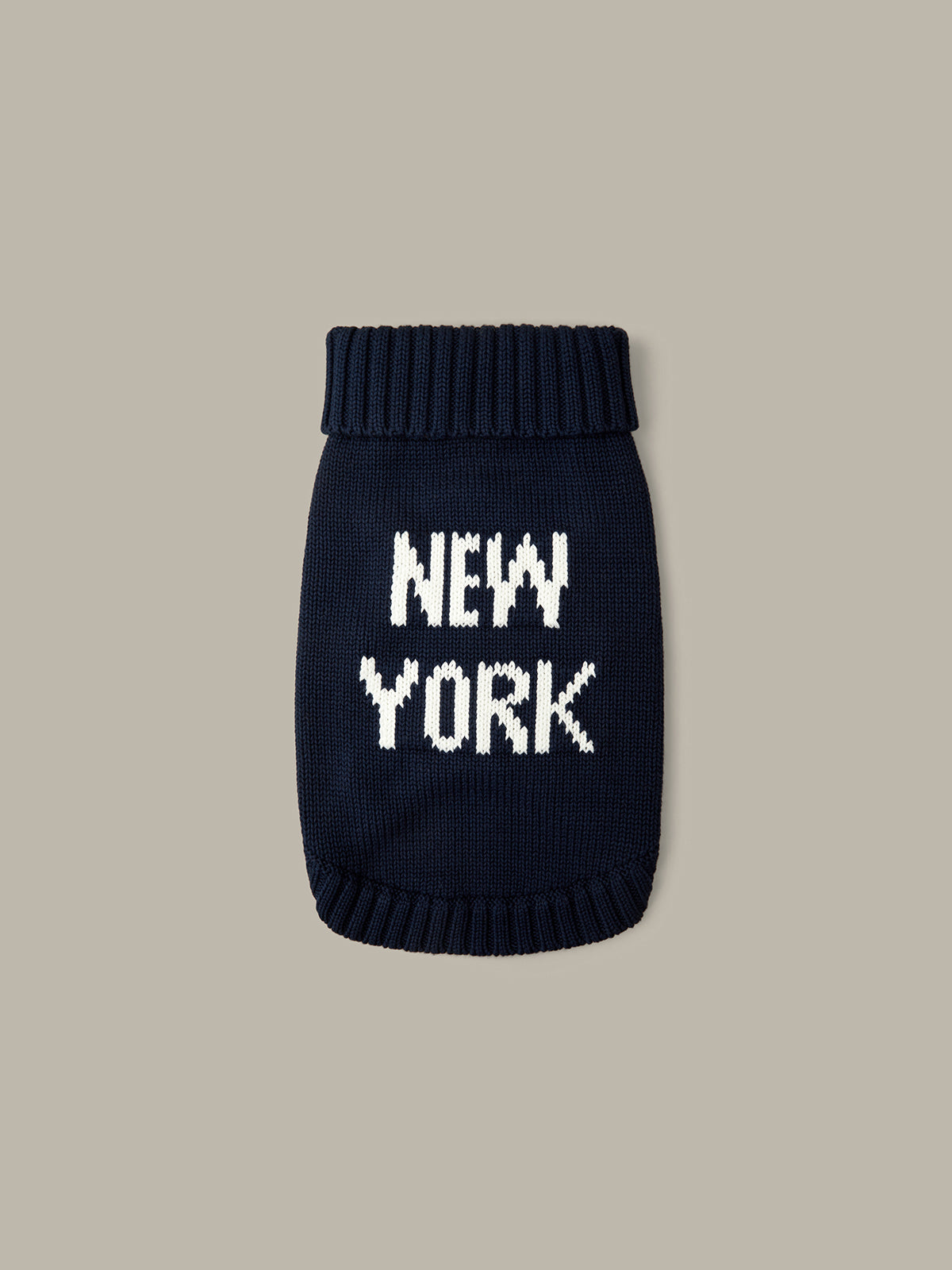 Black knit sweater with 'NEW YORK' text on a beige background