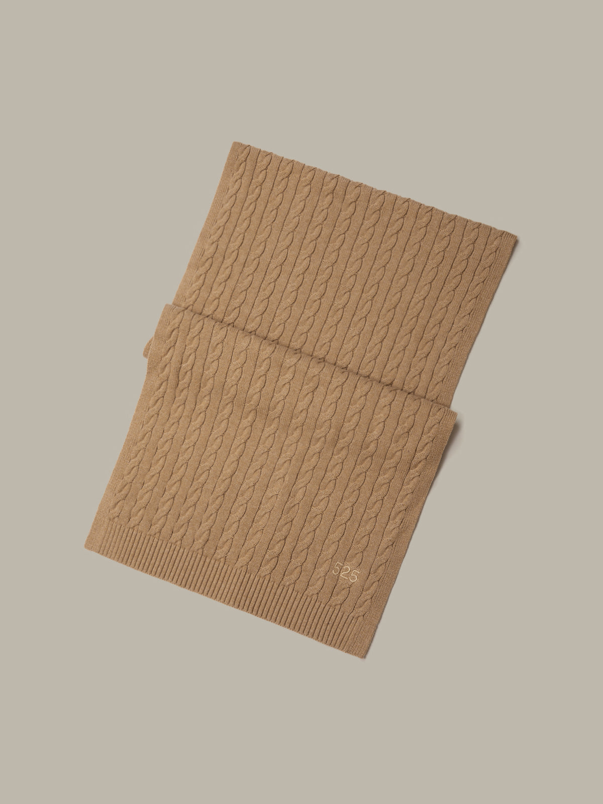 Folded brown knitted fabric on a beige background