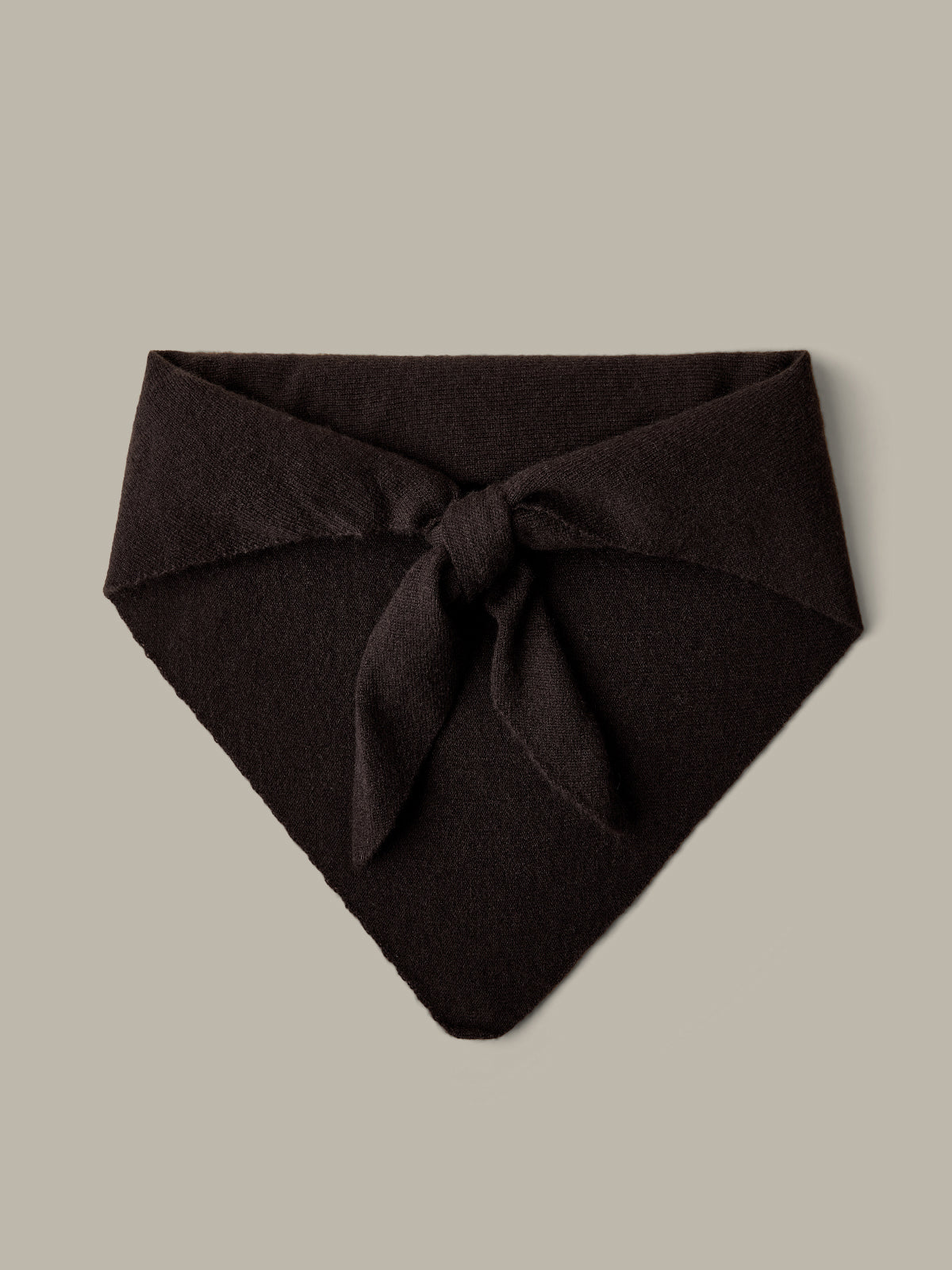 Dark brown fabric triangle with a knot on a beige background